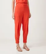 Pantalón jogger color naranja, con cintura elástica, hebilla y bolsillos laterales.