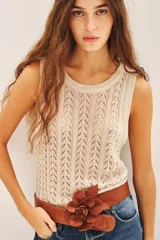 Musculosa sin mangas de tejido punto desagujado en color beige claro, con patrón de rombos calados y brillo sutil por el hilado de lurex y lentejuelas.