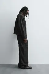 Pantalón relaxed fit confeccionado en denim de algodón color negro. Cuenta con bolsillos frontales, traseros de plastrón y bolsillos multifunción en las perneras. Tiene efecto lavado y cierre frontal con cremallera y botón.