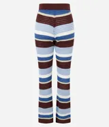 Pantalón femenino de punto con efecto crochet, de corte flare, cintura elástica y rayas horizontales en diferentes anchos y colores (azul claro, azul medio, bordó y blanco).