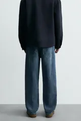 Pantalón de jean azul de corte recto, con cinco bolsillos, efecto lavado y cierre frontal con botones.