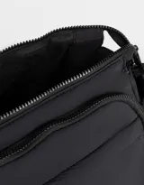 Bolso bandolera negro de tela deportiva con correa regulable y desmontable estampada, cierre superior, bolsillo frontal con cierre y bolsillos laterales con tira de ajuste.