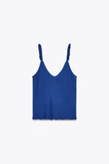 Top azul de punto con escote en pico y tirantes finos con volantes.