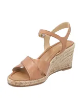 Sandalias con plataforma de yute color marrón claro, con dos tiras anchas cruzadas de cuero marrón y pulsera al tobillo con hebilla dorada.