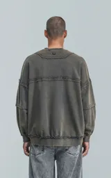 Buzo cuello redondo color gris oscuro con efecto gastado, costuras expuestas, calce oversize y roturas.