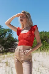 Top tejido color naranja con lurex, escote cuadrado y volados en los hombros.