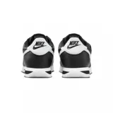 Zapatillas Nike Cortez negras con swoosh blanco de cuero, suela de goma blanca con línea negra y refuerzo blanco en el talón.