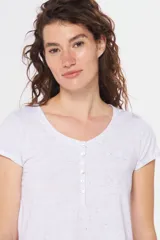 Remera color beige con escote redondo, manga corta, bolsillo en el pecho y cierre parcial con botones.