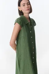 Vestido camisero celeste de lino, corte midi, con cuello camisero, mangas cortas con volados y abotonadura frontal.