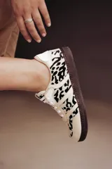 Zapatillas Adidas Samba con estampado animal print en blanco y negro, detalles en cuero beige y suela de goma color caramelo.