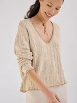 Buzo color beige con textura de líneas horizontales, escote en V y mangas largas.
