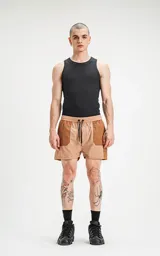 Short de baño de calce regular, color camel (marrón claro), con paneles de tela en tono marrón más oscuro en los bolsillos cargo laterales y en la parte superior de los bolsillos delanteros. Posee cintura elástica con cordón negro estampado.