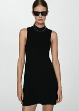 Vestido corto evasé color crudo, de tejido de punto fino, sin mangas y con cuello perkins.