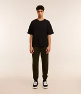 Pantalón jogger verde oscuro confeccionado en algodón y poliéster. Cuenta con cintura elástica ajustable con cordón, bolsillos laterales y puños elásticos en los tobillos.