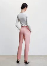 Pantalón recto de traje, con tejido fluido y diseño largo, cuenta con dos bolsillos laterales y cierre oculto de botón y cremallera.