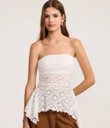 Blusa sin breteles de encaje blanco con escote recto y bajo con puntas diferenciadas.