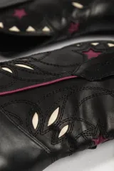 Botas de cuero negras con diseño de estilo western, con puntera fina y detalles de estrellas en color borgoña y blanco.
