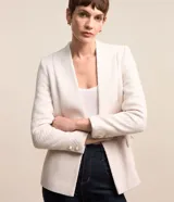 Blazer color crema en tejido tweed, de corte recto, sin solapa, con cierre frontal de un botón y bolsillos con solapa.