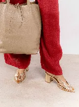 Sandalia negra de cuero con tiras finas entrecruzadas, punta fina, pulsera regulable en el tobillo y taco bloque.