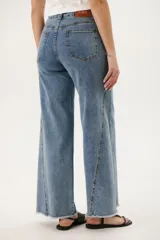 Pantalón de jean celeste de corte wide leg con terminación desflecada.