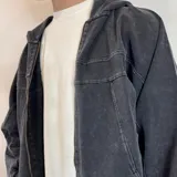 Campera con capucha de algodón color gris oscuro con efecto lavado y cierre frontal. Tiene bolsillos laterales y puños ajustados.