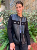 Campera negra con frente de cuero, mangas largas de tejido de punto y cierre frontal con cremallera.