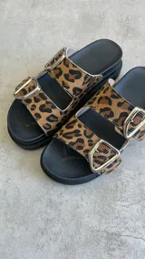 Sandalias con estampado animal print, dos tiras con hebillas plateadas y plataforma baja.