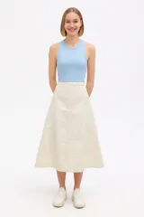Falda midi evasé color beige, confeccionada en lona.