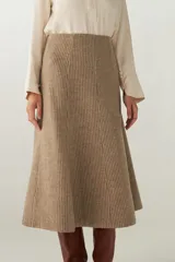 Falda midi evasé color beige, tejida en lana fina con detalle de pespuntes y cierre oculto.
