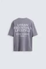 Camiseta gris de corte holgado, cuello redondo y manga corta. Estampado con la frase "Live in Style Everyday" en el frente.