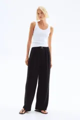 Pantalón sastre negro de punto crepé con pinzas, tiro alto, cintura elástica, cinturón decorativo con hebilla metálica y piernas amplias rectas.