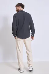 Camisa de manga larga color gris oscuro, con cuello clásico y cierre frontal con botones.