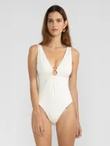 Malla enteriza blanca con escote en V y argolla metálica en el centro del busto.