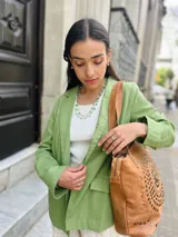 Blazer verde de lino, corte sastrero, con solapas y bolsillos delanteros.