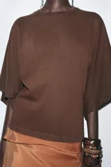 Camiseta blanca de algodón con cuello redondo y mangas cortas tipo capa.