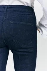 Pantalón de jean negro de tiro medio, corte bootcut y cinco bolsillos.
