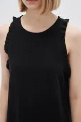 Vestido corto color crema, sin mangas, con cuello redondo y volados en los hombros.