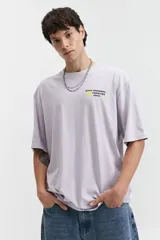 Remera color café de corte oversize con cuello redondo y mangas cortas. Estampado en la espalda con la frase "Stay Original Forever" y varios diseños gráficos.