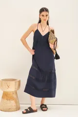 Vestido largo azul marino de breteles finos, línea "A" con volado en la parte inferior y detalles de puntillas alrededor de toda la prenda.