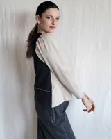 Remera negra de mangas largas con cuello en V y detalles de pespuntes blancos.