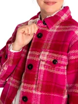 Chaqueta tipo camisa de lana a cuadros color fucsia, rojo y beige, con cuello camisero, cierre frontal con botones, dos bolsillos de parche en el pecho y mangas largas.