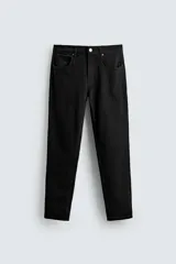 Pantalón de jean negro, corte slim fit, con tiro medio, cinco bolsillos, efecto lavado y cierre frontal con cremallera y botón.