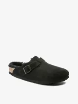 Sandalias tipo mules en ante negro con forro de lana de borrego, hebilla metálica y plantilla anatómica de corcho y látex.
