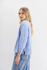 Cardigan celeste de tejido de punto con lentejuelas en el frente, calce relajado y mangas largas. Tejido con terminaciones en punto rib.