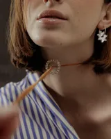 Gargantilla marrón de cuero sintético con dije circular con strass y lazos para atar.