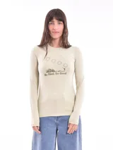 Remera manga larga color beige con cuello redondo y estampa frontal con dibujo de montañas, soles y texto "Be Kind, Do Good".