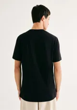 Camiseta blanca de algodón con cuello redondo y mangas cortas. Estampa rectangular con borde negro que contiene la frase "NATURAL ATMOSPHERE" en letras mayúsculas y una imagen de montañas y mar.