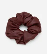 Accesorio para el pelo tipo scrunchie confeccionado en cuero sintético color bordó.