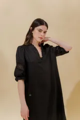 Vestido largo color beige, confeccionado en lino, con escote en V con volados y apliques de puntilla en las mangas. Posee bolsillos delanteros y tajos laterales.