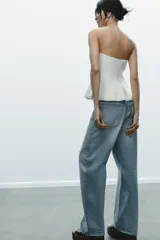 Top palabra de honor blanco con hombros descubiertos, corte ajustado y bajo con peplum.